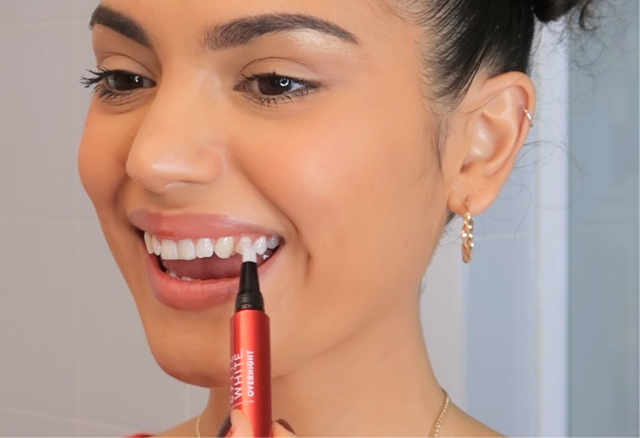 女士將美白精華塗抹於牙齒表面。